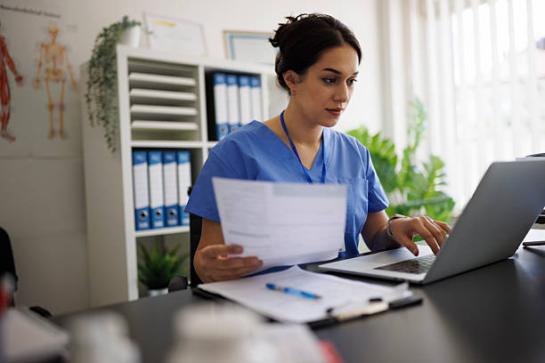 Nurse reviewing patient data on laptop